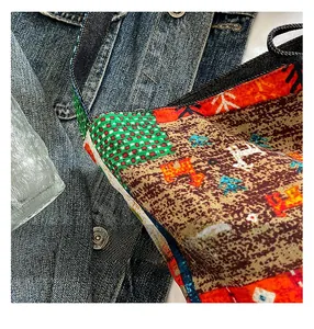 Close-up of ethnic patchwork denim bag featuring green checkers and animal motifs