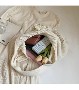Détail du sac en crochet montrant la grande capacité et les motifs de marguerites 3D