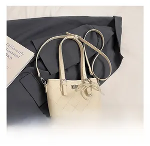 Detail of cream quilted bucket bag with pearl bow charm and silver twist lock closure