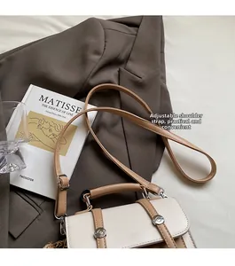 Detail showing the adjustable thin shoulder strap and silver metal buckle of the bag