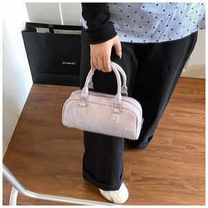 Détail du sac bowling violet clair montrant les zips argentés et la texture cuir