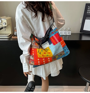 Close-up of a large bohemian patchwork tote bag with SEEYOU label worn by a model