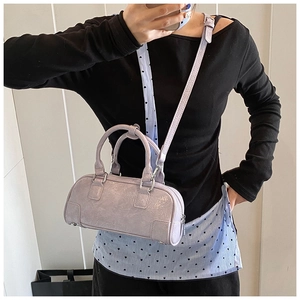 Selfie miroir montrant un mini sac Boston lavande avec chaîne argentée et bandoulière