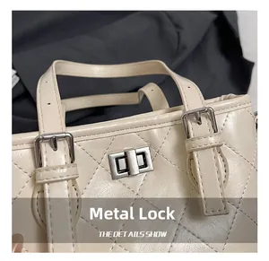 Detailed close-up of beige quilted leather handbag featuring a silver hardware twist lock