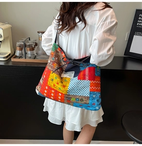 Detail of colorful patchwork tote bag with SEE YOU text and bohemian fabric patterns