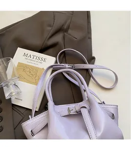 Détail du sac seau en cuir lavande avec bandoulière réglable et boucle métallique élégante