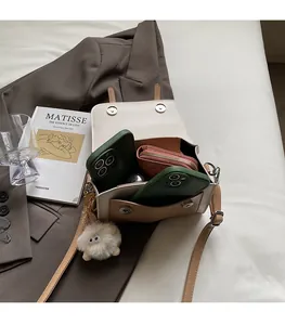 Spacious interior of beige crossbody bag holding two smartphones and a thick wallet