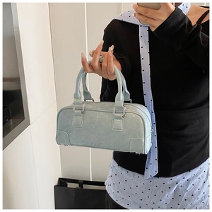 Détails du sac bowling bleu clair en cuir verni froissé avec finitions métalliques argent