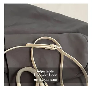 Detail of adjustable cream white synthetic leather shoulder strap with silver metal buckle