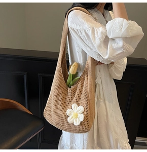 Détail du sac cabas en maille beige avec breloque marguerite et texture tissée