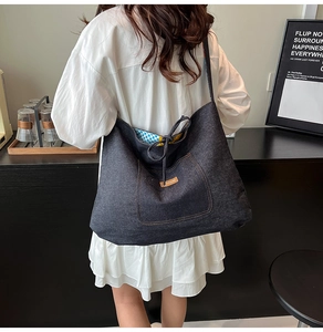 Detail of grey denim tote bag with decorative pocket and blue checkered lining detail