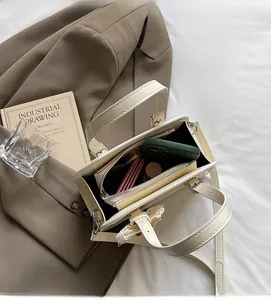 Spacious interior of beige patent leather Boston bag with daily essentials inside