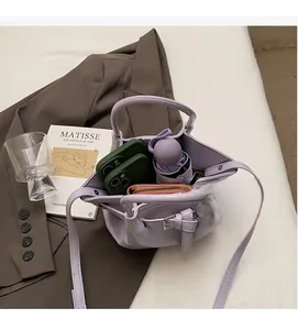 Sac seau violet en similicuir montrant un grand intérieur avec téléphone et parapluie