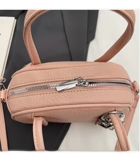 Détail macro de la fermeture éclair en métal et du cuir grainé rose sur le sac à main