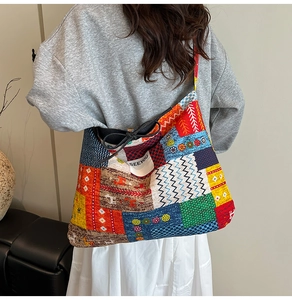 Detail of multi-color patchwork denim tote bag with drawstring closure and logo label