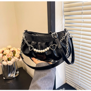 Détail du sac plissé noir à motif crocodile avec chaînes argentées et perles