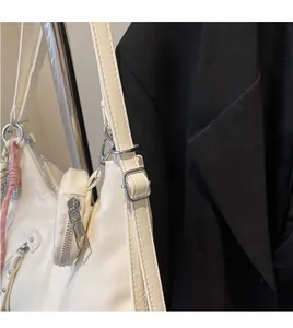 Close-up of a white crescent shoulder bag with adjustable strap and small round pouch