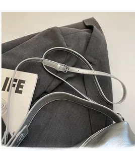 Detail of adjustable silver leather shoulder strap with metallic buckle on pillow bag