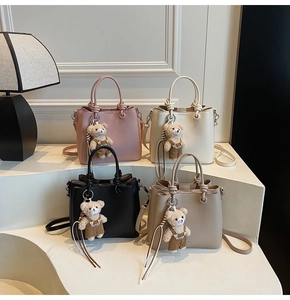 Litchi pattern bucket bags in four colors with knotted handles and plush bear charms
