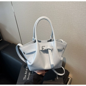 Détail de la texture en cuir ciré bleu clair et boucle argentée d'un sac seau chic