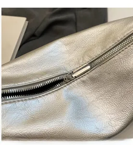 Detailed macro shot of a metallic silver textured bag featuring a smooth metal zipper