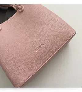 Close-up of pink litchi grain leather shoulder bag with CLEAR K logo and neat stitching