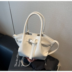 Détail du sac seau en similicuir beige avec boucle argentée et plis élégants