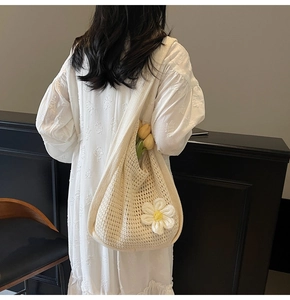 Détail d'un sac cabas en tricot avec fleur marguerite 3D et texture crochet
