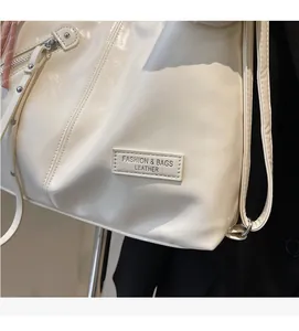 Detailed macro shot of off-white leather tote bag with silver zipper and brand tag