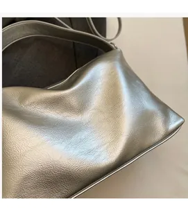Close-up of metallic silver faux leather texture and soft wrinkled finish on the handbag
