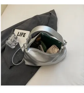 Interior view showing spacious storage capacity of silver shoulder bag with daily items