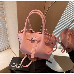 Sac seau rose en cuir verni avec sangles décoratives et boucles en métal argenté
