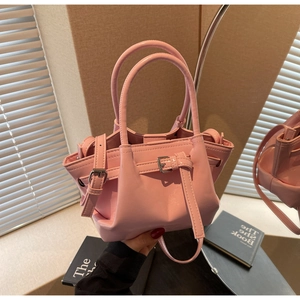 Détail du sac seau rose brillant avec boucle argentée et poignées rondes élégantes
