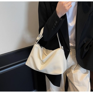 Detail of minimalist beige underarm bag in lychee leather with silver metal hardware