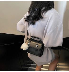 Fashionable black faux leather crossbody bag with cute white plush sheep charm pendant