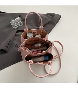 Internal view of pink bucket bag showing three spacious storage compartments and lining