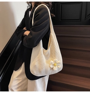 Détail du sac cabas en crochet blanc avec fleur marguerite 3D porté à l'épaule par un mannequin