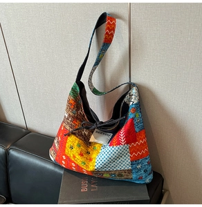 Macro detail of patchwork denim tote with ethnic patterns and black drawstring closure