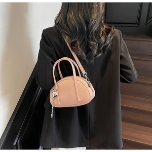 Détail du sac bandoulière rose grainé avec pendentif cœur et chaîne argentée chic