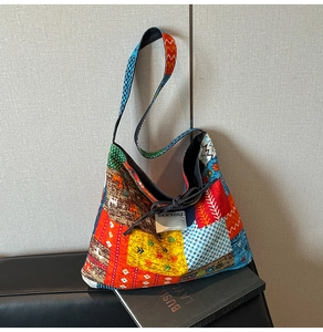 Detail of colorful patchwork tote bag with ethnic patterns on a black leather sofa