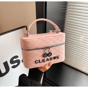 Détail du sac matelassé rose avec logo métallique et pendentifs de zip floraux