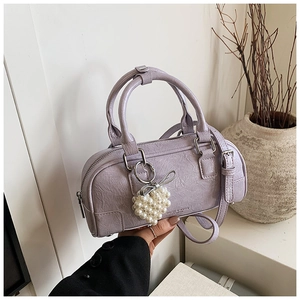 Détail du sac Boston plissé lavande avec breloque cœur en perle et un nœud