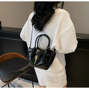Vue de dos d'un grand sac à main en cuir verni noir brillant porté par un mannequin