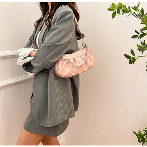 Détail du sac rose embossé crocodile avec chaîne cœur en perles et fine bandoulière