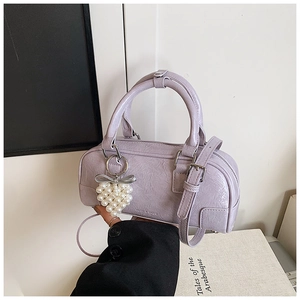 Détail du sac polochon lavande avec finition plissée brillante et breloque cœur perlé