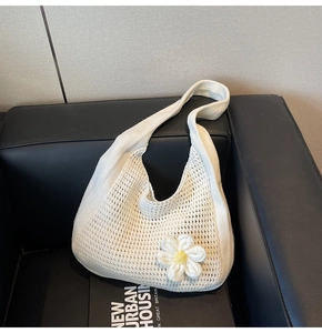 Détail rapproché du sac cabas en maille blanche avec fleur de marguerite en relief