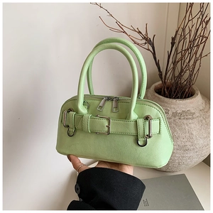 Detail of mint green shell bag with silver double zippers and decorative buckle