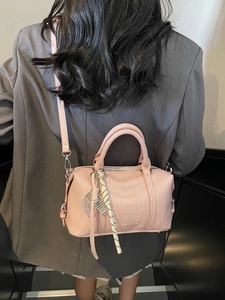 Bolso tipo bowling de cuero sintético rosa con correa cruzada y colgante deportivo