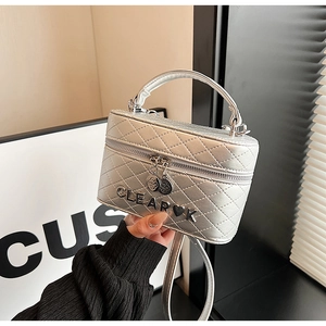Détail du sac boîte en cuir argenté matelassé avec logo CLEAR K et bandoulière