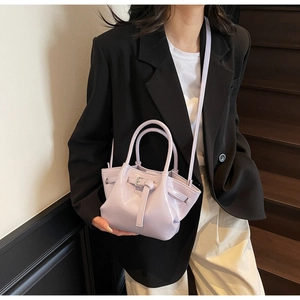 Détail du sac seau en cuir ciré violet clair avec finition brillante et bandoulière